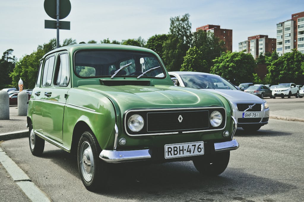 Classic Renault car with green exterior parked in a sunny Kotka, Finland cityscape.